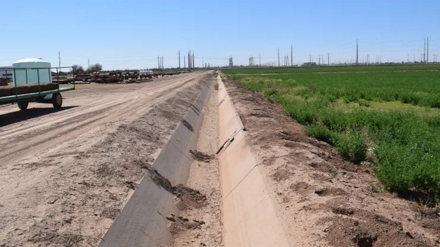 An empty irrigation canal runs along an alfalfa field owned by Caywood Farms, a cotton farm near Casa Grande, Arizona in April 2022. Photo: Emma Newburger / CNBC