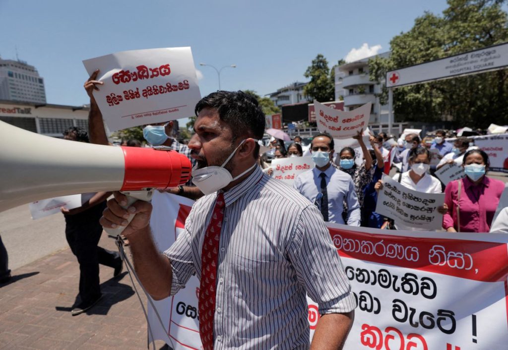 Government Medical Officers’ Association members walk with placards protesting against Sri Lankan President Gotabaya Rajapaksa after his government lost its majority in the parliament during a demonstration near the parliament building in Colombo, Sri Lanka, 6 April 2022. Dinuka Liyanawatte / REUTERS