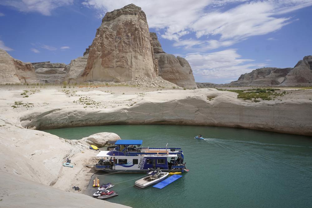 A houseboat rests in a cove at Lake Powell near Page, Arizona on 30 July 2021. In the summer of 2021, the water levels hit a historic low amid a climate change-fueled megadrought engulfing the U.S. West. Severe drought across the West drained reservoirs in 2021, slashing hydropower production and further stressing the region’s power grids. And as extreme weather becomes more common with climate change, grid operators are adapting to swings in hydropower generation. Photo: Rick Bowmer / AP Photo