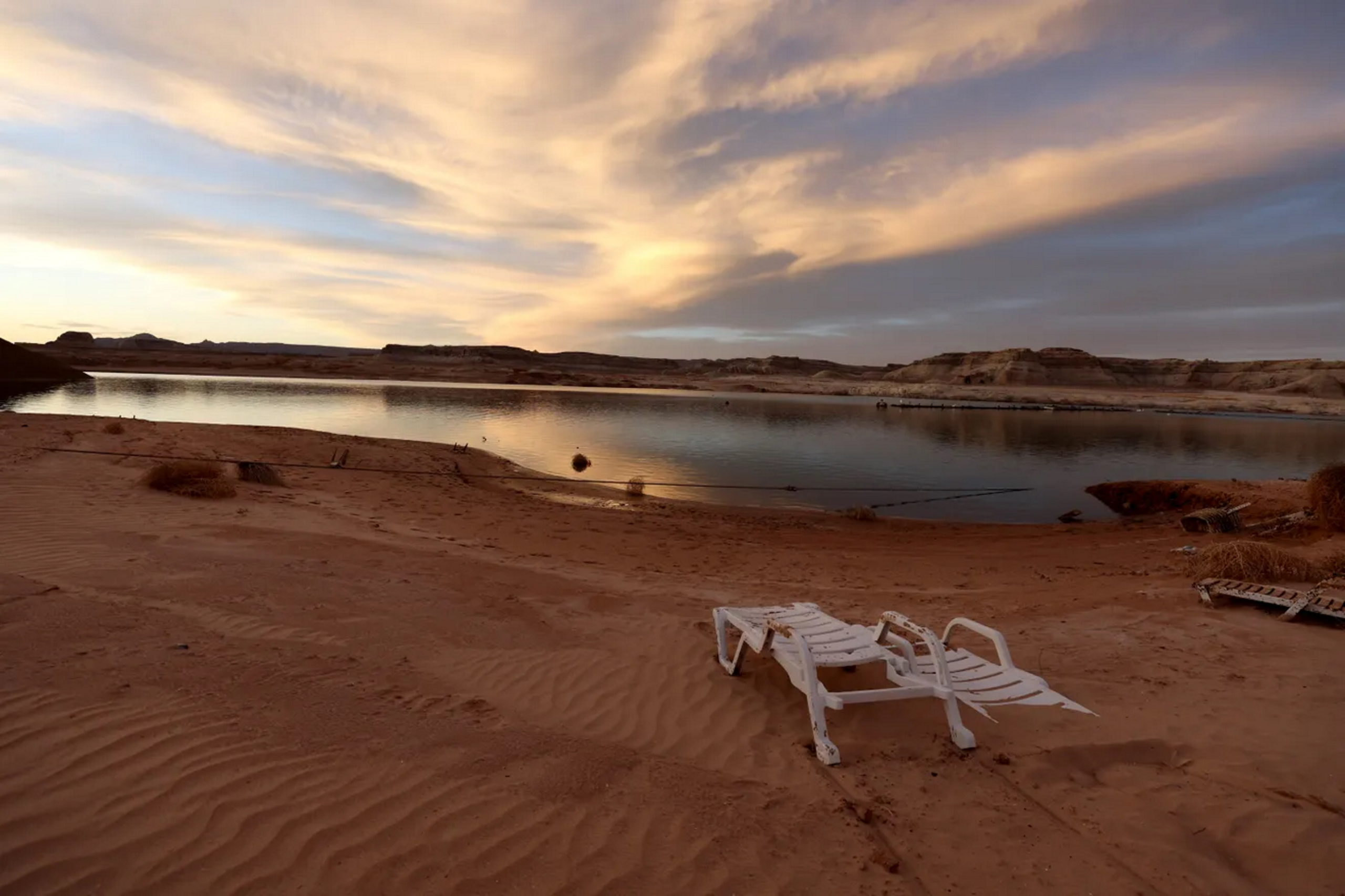 A discarded lounge chair sits on the banks of Wahweap Bay as the sun sets over Lake Powell on 27 March 2022 in Big Water, Utah. Photo: Justin Sullivan / Getty Images