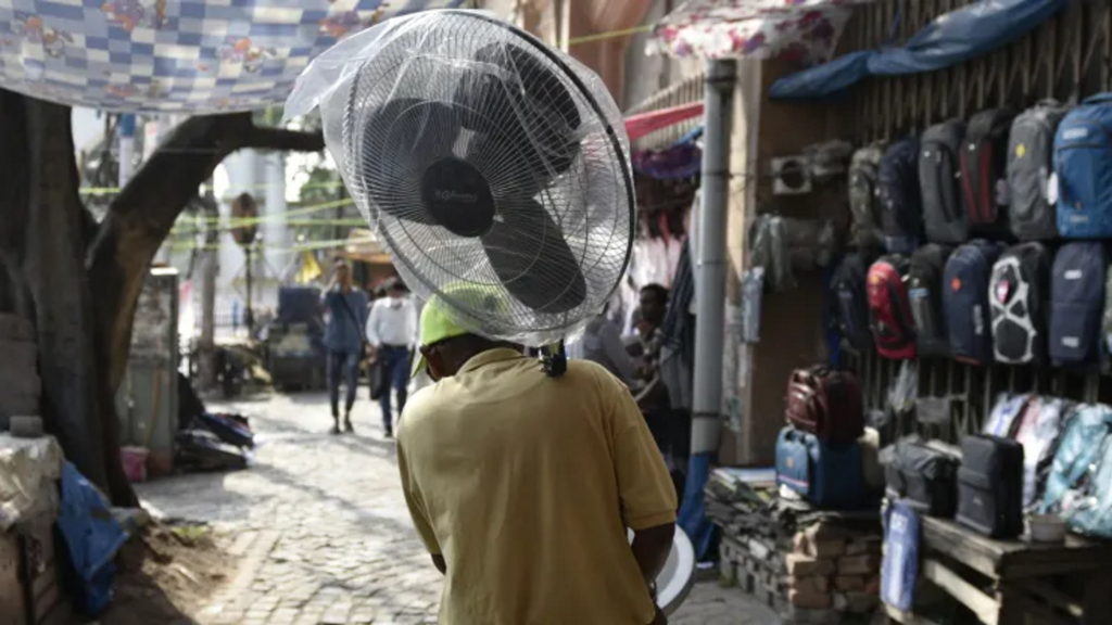 A man carries a pedestal fan amid heatwave in Kolkata, India, 26 April 2022. Photo: Indranil Aditya / Nurphoto / Getty Images