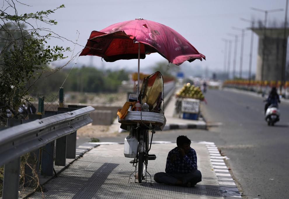 A snacks vendor sits under a shade and waits for customer on a hot summer afternoon in Jammu, India, 19 May 2022. Many parts of north west and central India continued to experience heatwave conditions. Photo: Channi Anand / AP