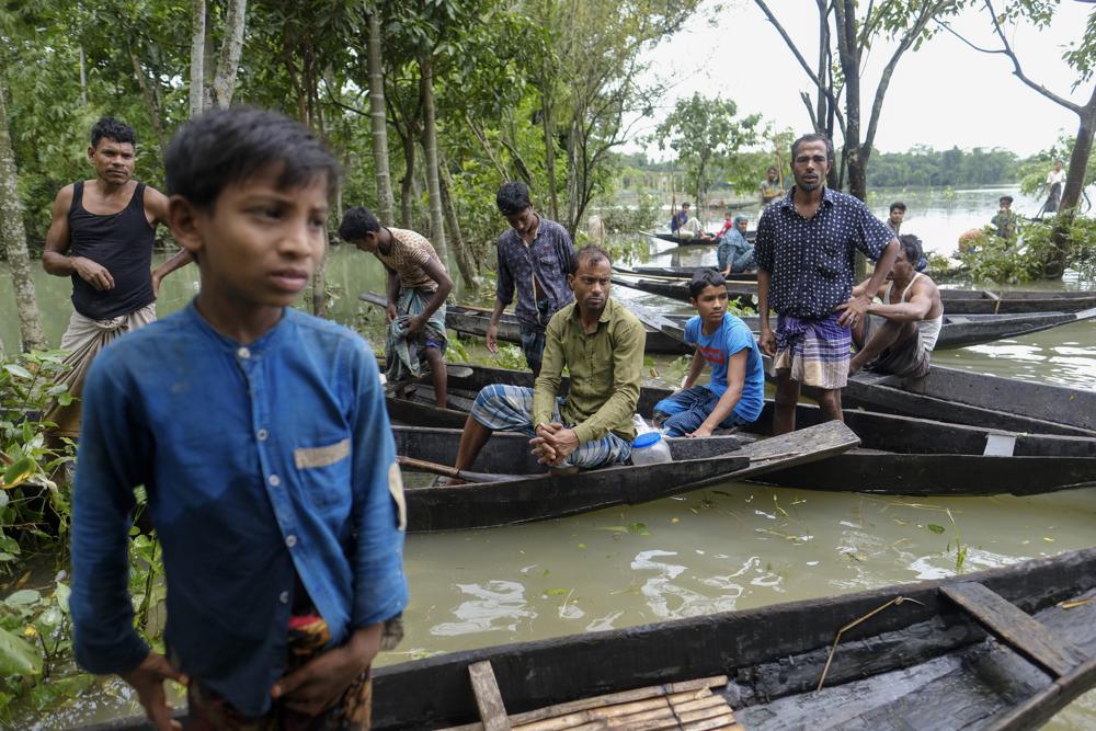 Flood-affected people wait with boats to receive relief material in Sylhet, Bangladesh, Wednesday, 22 June 2022. Photo: Mahmud Hossain Opu / AP Photo