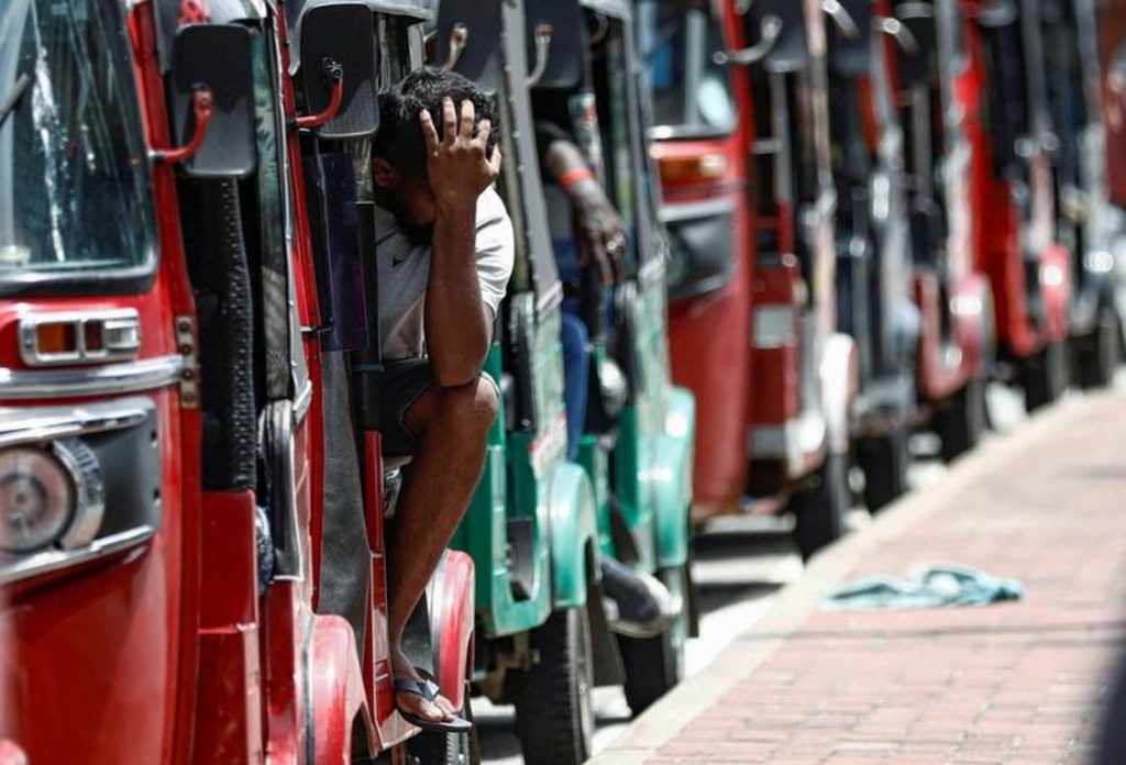A man waits inside a three-wheeler near a line to buy petrol from a fuel station, amid the country's economic crisis, in Colombo, Sri Lanka, 23 May 2022. Photo: Dinuka Liyanawatte / REUTERS