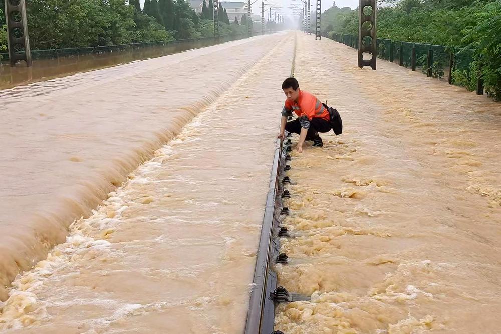 A worker checks a section of flooded railway in Shangrao in central China's Jiangxi province, Tuesday, 21 June 2022. Photo: Chinatopix / AP