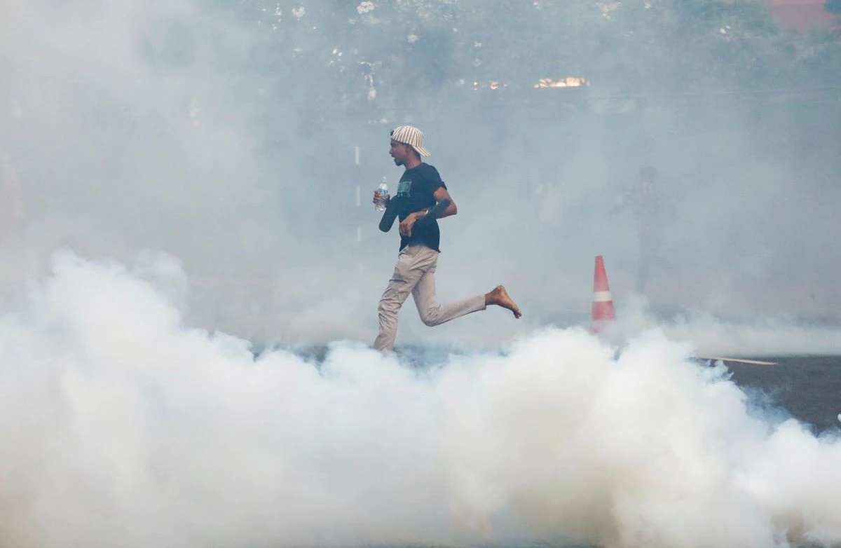 A protester runs as police use tear gas and water cannons to disperse demonstrators near President’s residence during a protest demanding the resignation of President Gotabaya Rajapaksa, amid the country’s economic crisis, in Colombo, Sri Lanka, 8 July 2022. Photo: Dinuka Liyanawatte / REUTERS