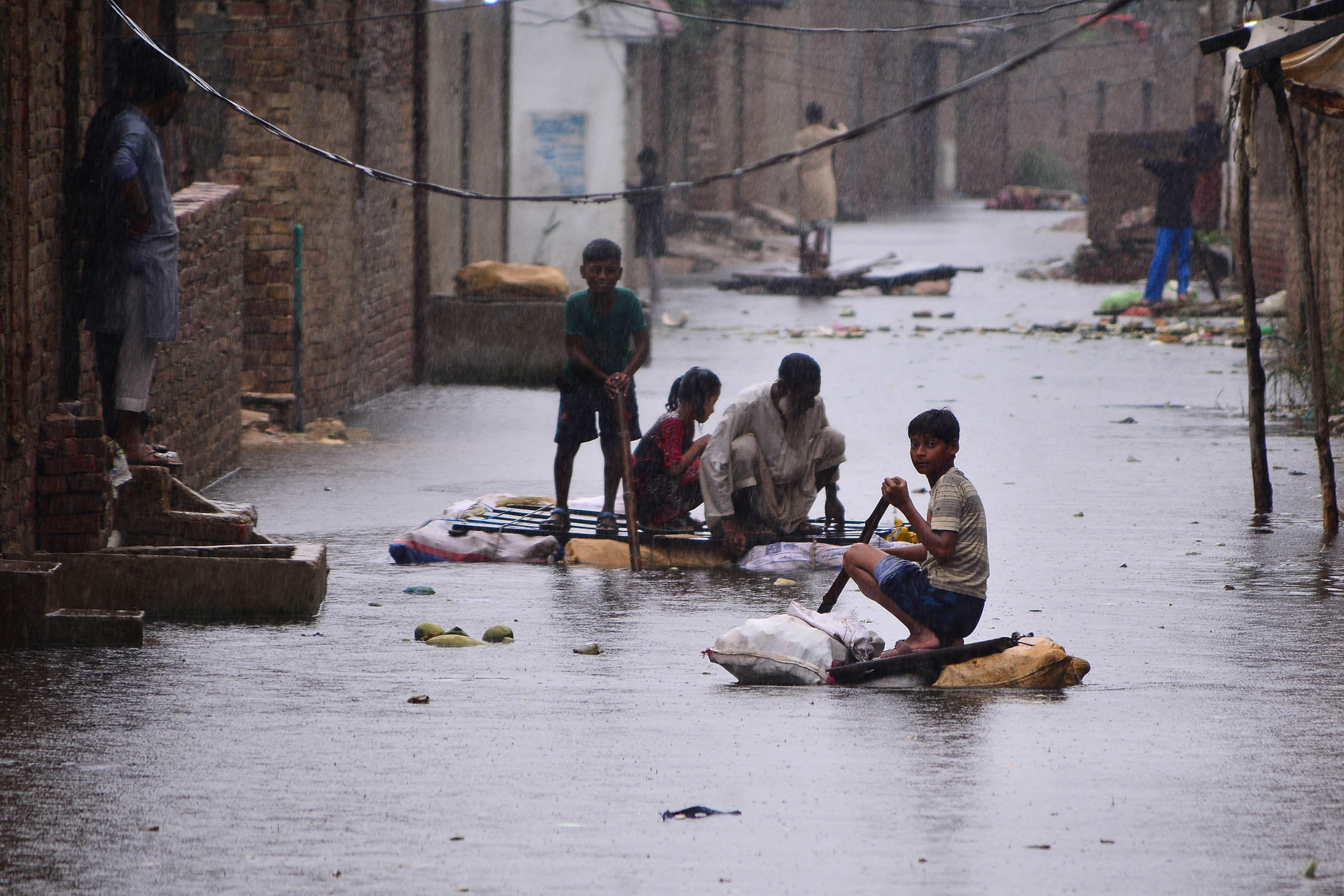Children use rafts to make their way along a waterlogged street in a residential area after a heavy monsoon rainfall in Hyderabad on 24 August 2022. Record monsoon rains were causing a “catastrophe of epic scale”, Pakistan's Climate Change Minister said August 24, announcing an international appeal for help in dealing with floods that have killed more than 800 people since June 2022. Photo: Akram SHAHID / AFP