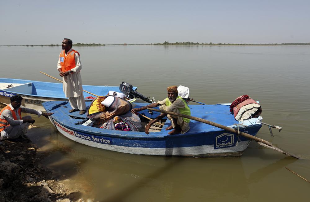 Victims of the unprecedented flooding from monsoon rains receive relief aid, organized by the Islamic group Jamaat-e-Islami Pakistan, in Sukkur, Pakistan, Sunday, 4 September 2022. Officials warned Sunday that more flooding was expected as Lake Manchar in southern Pakistan swelled from monsoon rains that began in mid-June and have killed nearly 1,300 people. Fareed Khan / AP Photo