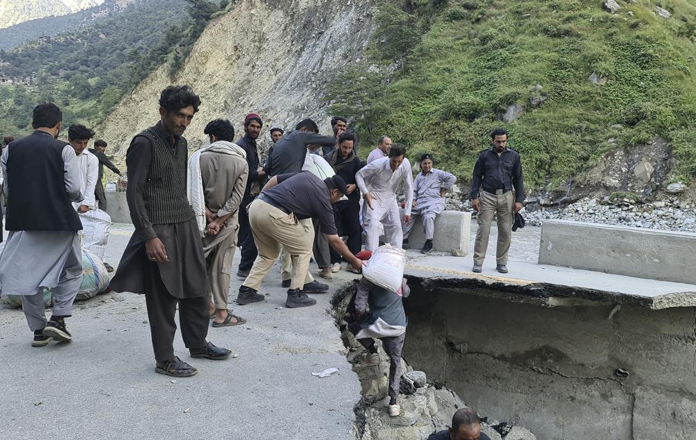 Local residents carry food and cross a portion of road destroyed by floodwaters in Kalam Valley in northern Pakistan, Sunday, 4 September 2022. Several countries have flown in supplies, but the Pakistani government has pleaded for even more help, faced with the enormous task of feeding and housing those affected, as well as protecting them from waterborne diseases. Photo: Sherin Zada / AP Photo