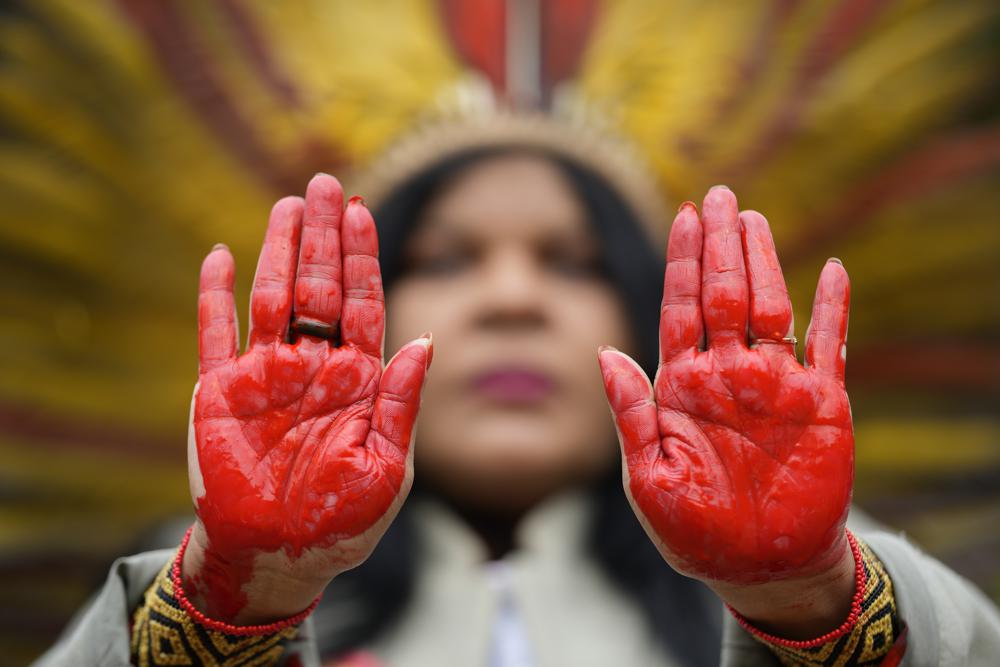 Indigenous leader Sonia Guajajara from the Guajajara ethnic group shows her hands painted in red symbolizing blood, during a protest against Violence, illegal logging, mining and ranching, and to demand government protection for their reserves, one day before the celebration of "Amazon Day," in Sao Paulo, Brazil, Sunday, 4 September 2022. Photo: Andre Penner / AP Photo