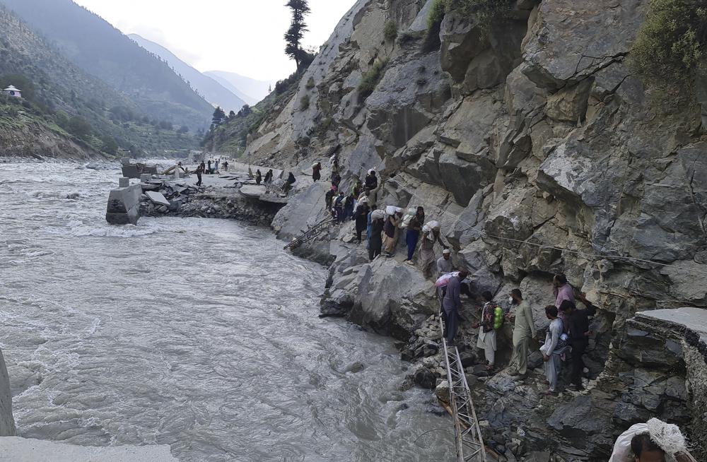 Local residents cross a portion of road destroyed by floodwaters in Kalam Valley in northern Pakistan, Sunday, 4 September 2022. More than 1,300 people have died and millions have lost their homes in flooding caused by unusually heavy monsoon rains in Pakistan this year that many experts have blamed on climate change. Photo: Sherin Zada / AP Photo