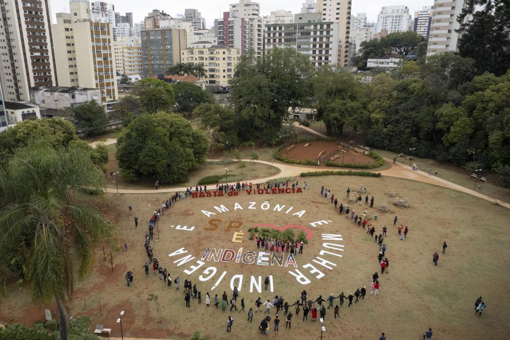 Indigenous people from several tribes form a circle with written messages that read in Portuguese “The Amazon is an Indigenous woman, Sao Paulo is Indigenous land, enough with violence,” during a protest against Violence, illegal logging, mining and ranching, and to demand government protection for their reserves, one day before the celebration of “Amazon Day”, in Sao Paulo, Brazil, Sunday, 4 September 2022. Photo: Andre Penner / AP Photo