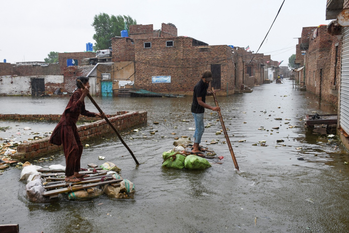 Men paddle on makeshift rafts as they cross a flooded street in Hyderabad, Pakistan in August 2022. Photo: Yasir Rajput / Reuters