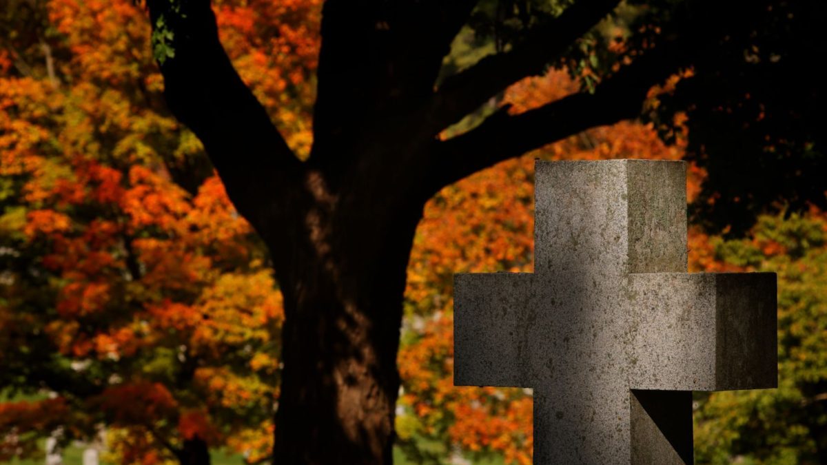 The grave marker of Matthew and Catherine King, who died in 1932 and 1947 respectively, catches broken light on Wednesday, 27 October 2021, against turning leaves at Calvary Cemetery in St. Louis, signaling the Autumn season. Photo: Christian Gooden / St. Louis Post-Dispatch