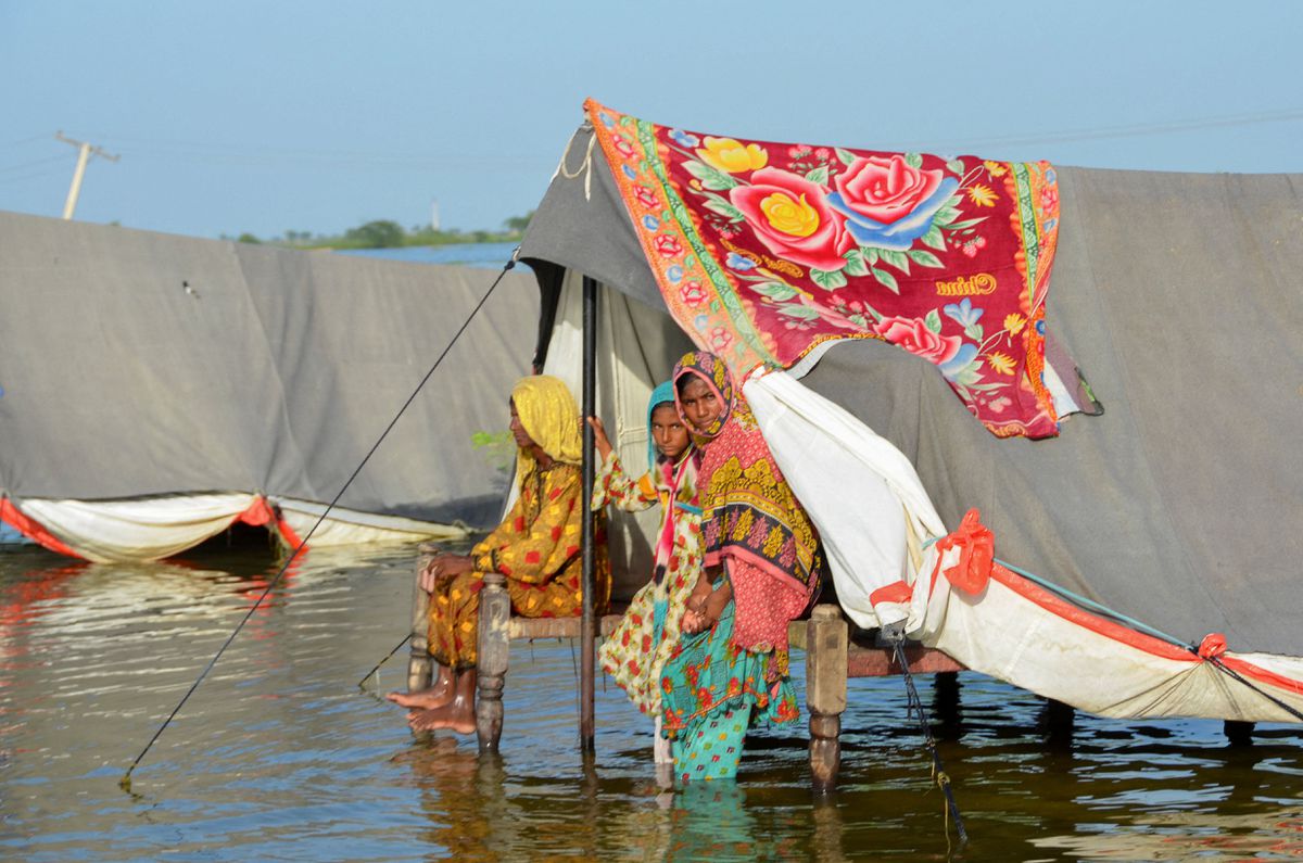 Flood victim family takes refuge with their belongings as floodwater rises, following rains and floods during the monsoon season in Sohbatpur, Pakistan, 4 September 2022. Photo: Amer Hussain / REUTERS