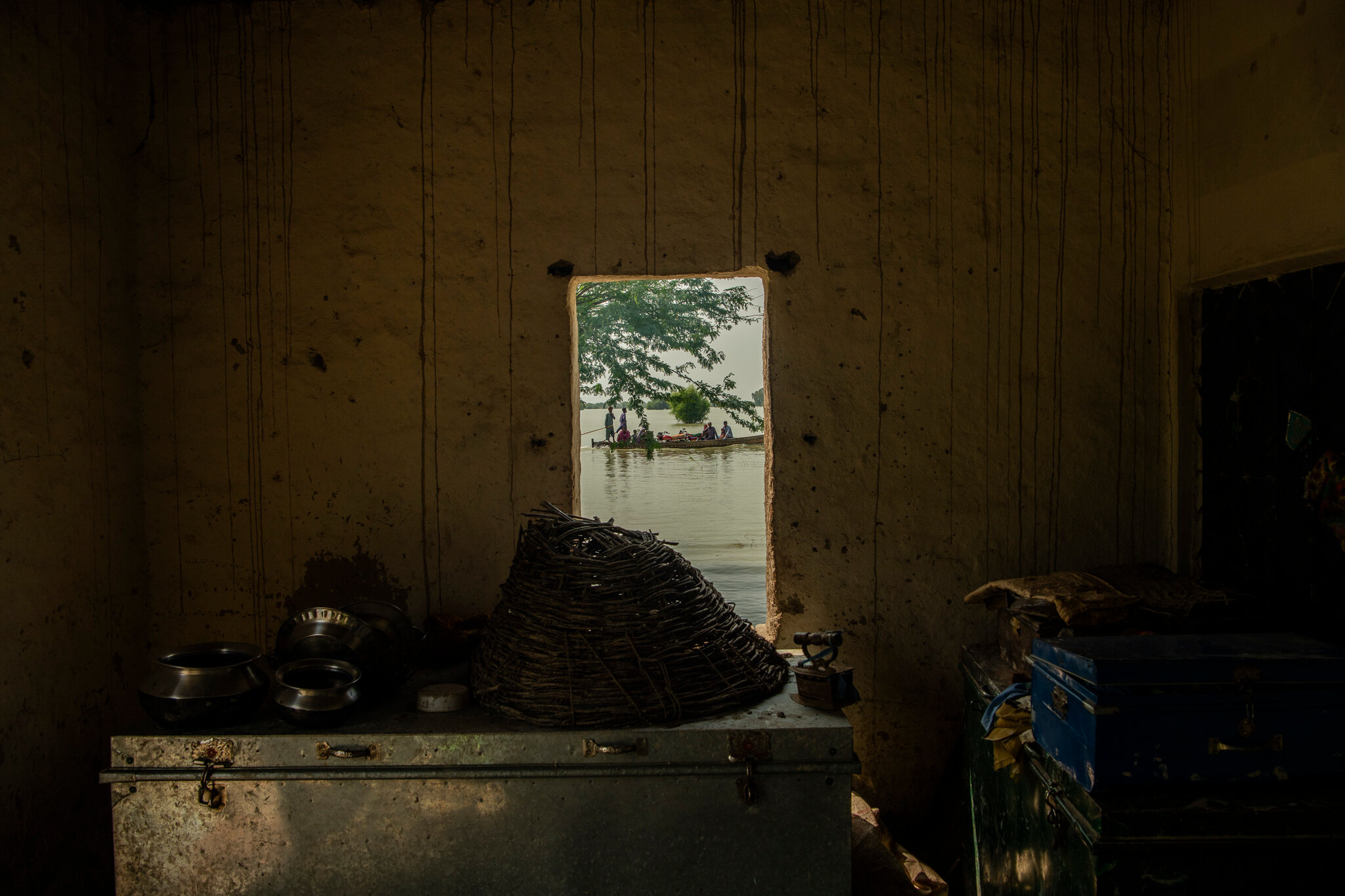 Munir Ahmad and his family stack up all of their belonging against the walls in the back of the house in Juma Khan Lagha village in Sindh. Photo: Kiana Hayeri / The New York Times