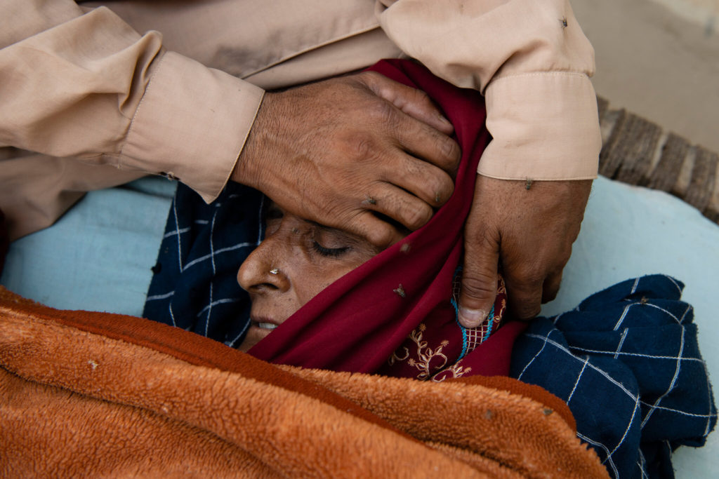 Muhammad Jaffar cares for his wife, who has been sick with malaria, in the village of Wado Khosa, Pakistan. Photo: Kiana Hayeri / The New York Times
