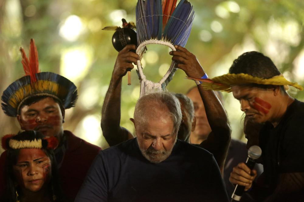 Brazil's former president who is running for reelection, Luiz Inacio Lula da Silva, receives a headdress from Assurini Indigenous people during a meeting with traditional populations from the Amazon in Belem, Para state, Brazil, 2 September 2022. Despite the smoke clogging the air of entire Amazon cities, state elections have largely ignored environmental issues. Far-right President Jair Bolsonaro is seeking a second four-year term against leftist da Silva, who ruled Brazil between 2003 and 2010. Photo: Raimundo Pacco / AP Photo
