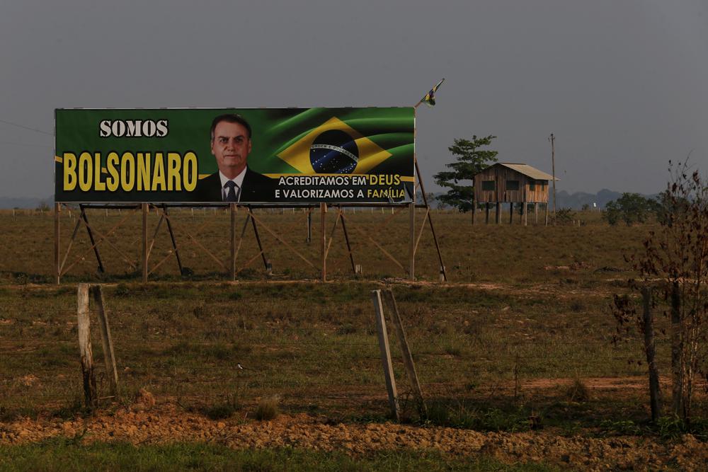 A billboard in support of the Brazilian President who is running for reelection, Jair Bolsonaro, with phrases written in Portuguese, left, “We are Bolsonaro”, right, “We Believe in God and Value the Family”, is displayed at the entrance of a farm in the municipality of Humaita, Amazonas state, Brazil, 17 September 2022. Far-right President Jair Bolsonaro is seeking a second four-year term against leftist Luiz Inácio Lula da Silva, who ruled Brazil between 2003 and 2010 and leads the polls. Photo: Edmar Barros / AP Photo