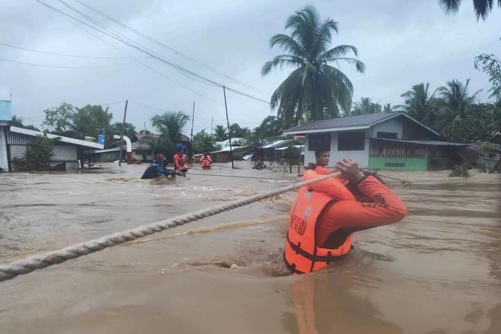 In this photo provided by the Philippine Coast Guard, rescuers use ropes as they evacuate residents from flooded areas due to Tropical Storm Nalgae at Parang, Maguindanao province, southern Philippines on Friday, 28 October 2022. Floodwaters rapidly rose in many low-lying villages, forcing some villagers to climb to their roofs, where they were rescued by army troops, police and volunteers, officials said. Photo: Philippine Coast Guard / AP News