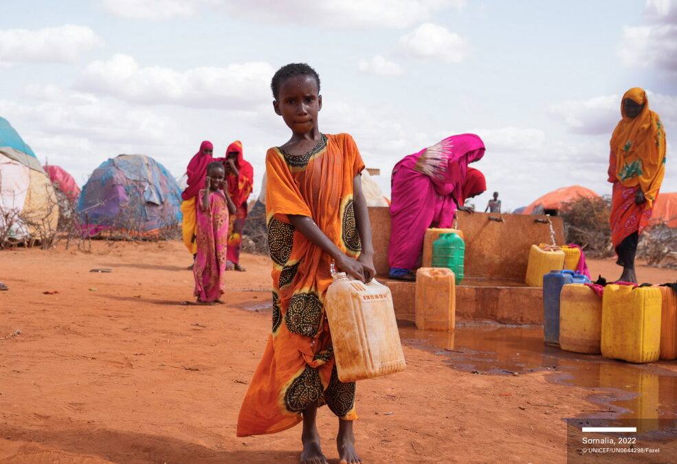 A child in a refugee camp carries water in Somalia, 2022. Somalia faces widespread famine after four failed rainy seasons, with a fifth season underway that likely will fail too, along with the sixth early in 2023. Photo: Fazel / UNICEF