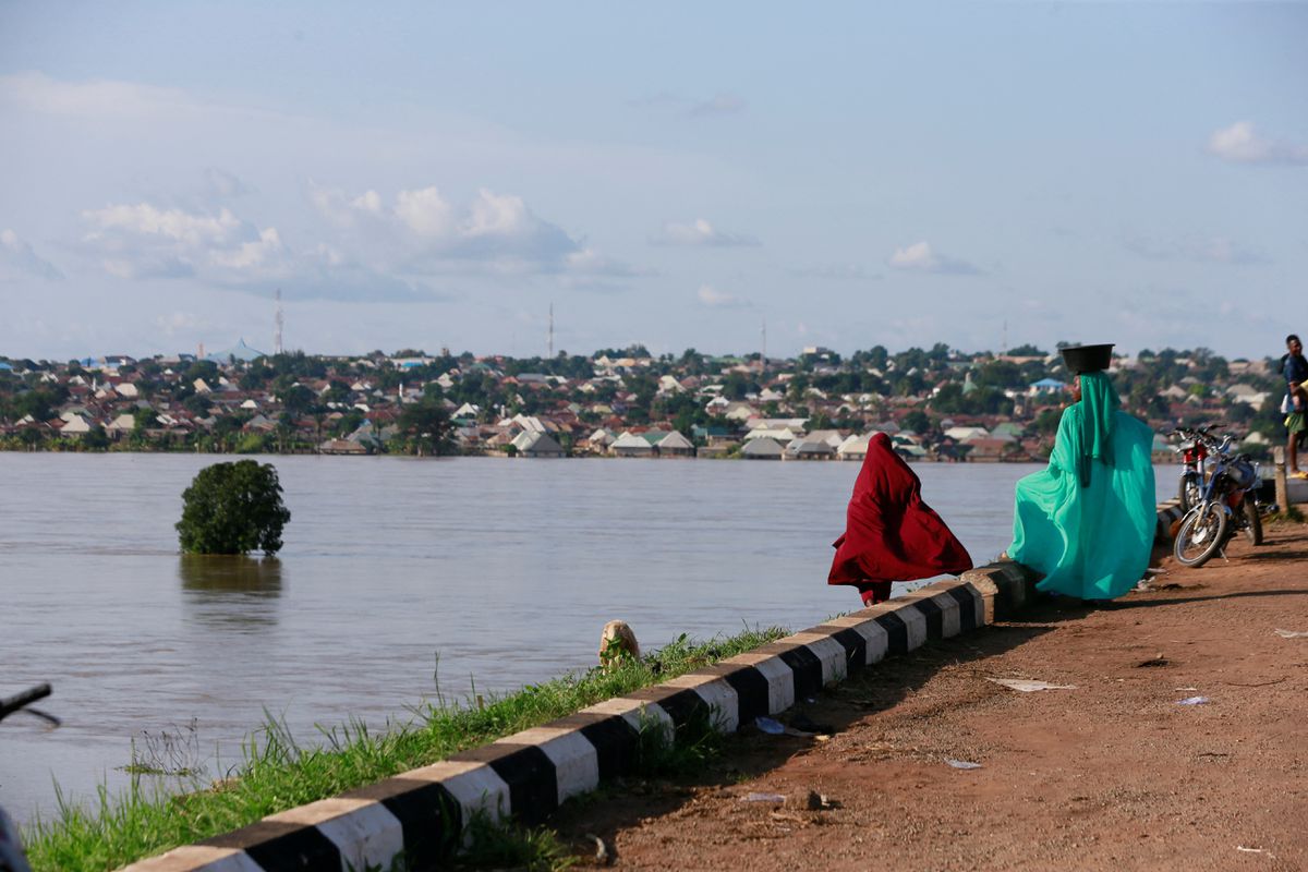Two women look on as the Benue River overflows and floods homes on the bank in Makurdi, Nigeria, 1 October 2022. Photo: Afolabi Sotunde / REUTERS