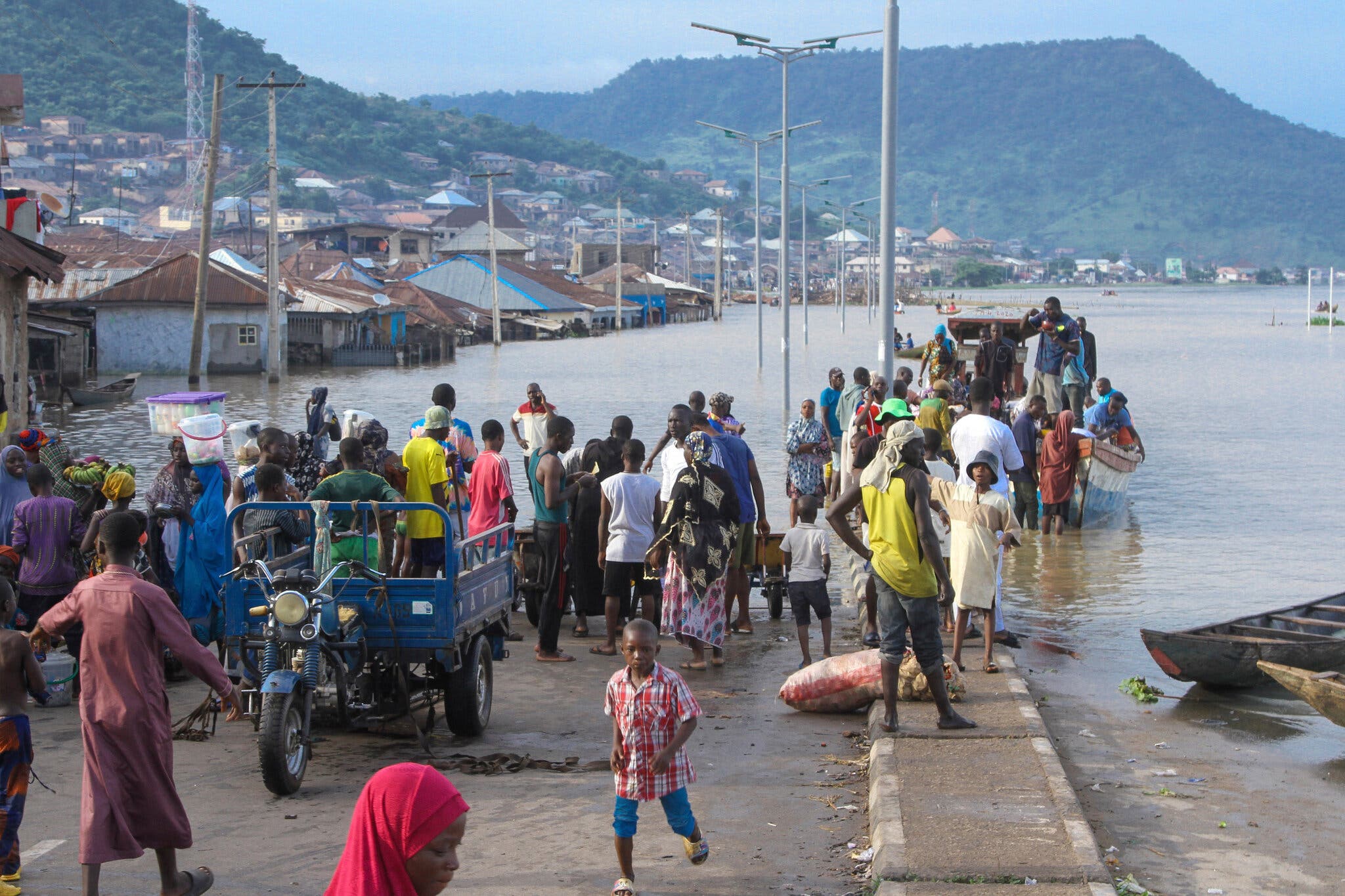 People stranded on a half-submerged road in Kogi, a central state, on 6 October 2022. Twenty-seven of Nigeria’s 36 states are affected by the floods. Photo: Fatai Campbell / Associated Press
