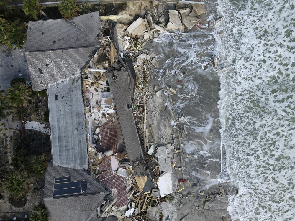 Waves lap the eroded beach below a home that half collapsed after the sand supporting it was swept away, following the passage of Hurricane Nicole, Saturday, 12 November 2022, in Wilbur-By-The-Sea, Fla. Photo: Rebecca Blackwell / AP Photo