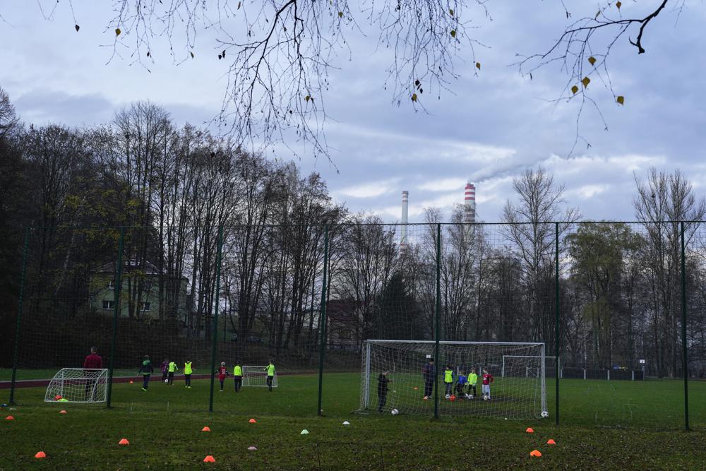 Children play soccer as smoke rises from chimneys of coal-fired power plant Detmarovice near Ostrava, Czech Republic, Thursday, 10 November 2022. High energy prices linked to Russia’s war on Ukraine have paved the way for coal’s comeback, endangering climate goals and threatening health from increased pollution. Photo: AP Photo / Petr David Josek