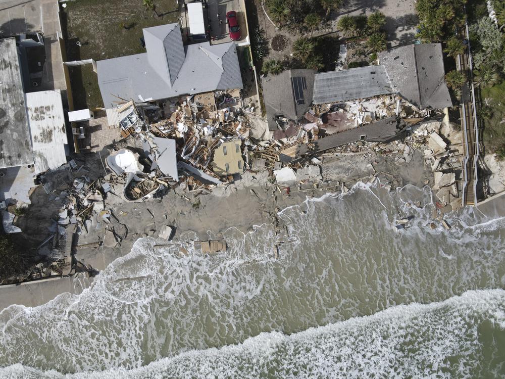 Waves lap the eroded beach below the half-collapsed homes of Nina Lavigna, at left, and her neighbor, after Hurricane Nicole swept away sand from the beach and from under foundations, Saturday, 12 November 2022, in Wilbur-By-The-Sea, Fla. Photo: Rebecca Blackwell / AP Photo