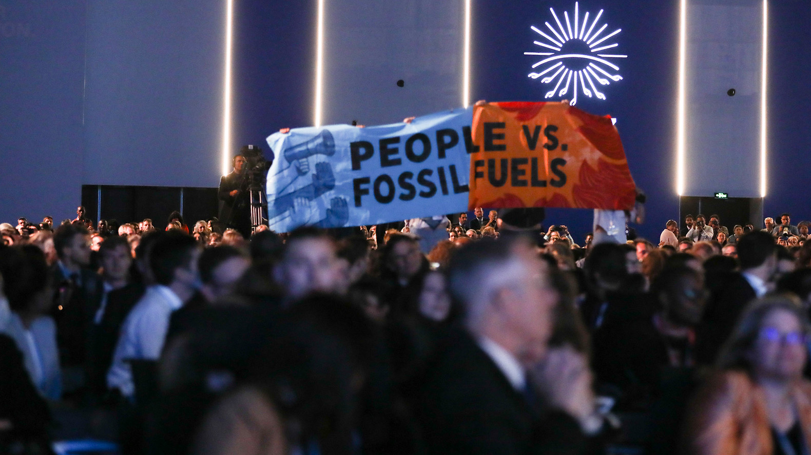 Protesters at the COP27 climate conference hold a banner that reads, “People vs. Fossil Fuels” on 11 November 2022. Photo: Kiara Worth / UNFCCC