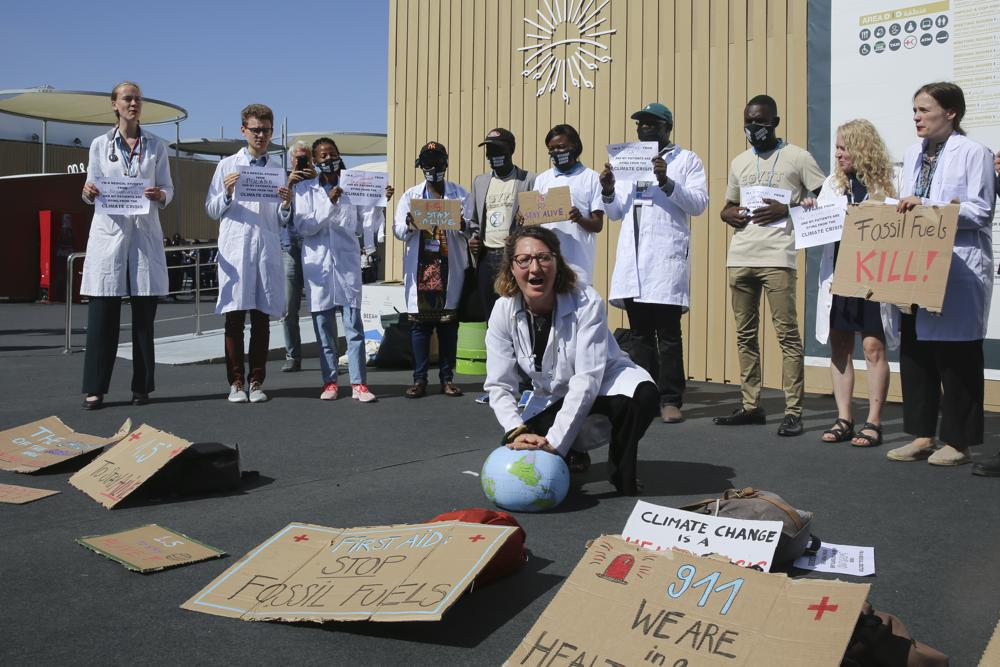 A medical worker performs a symbolic “artificial respiration” on a globe as health care workers from various countries perform a “die-in” to protest the effect of climate change on health issues at the COP27 U.N. Climate Summit, Friday, 11 November 2022, in Sharm el-Sheikh, Egypt. Photo: Thomas Hartwell / AP Photo