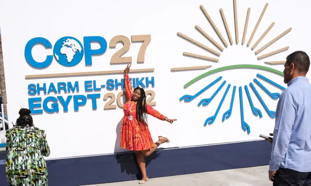 A woman poses in front of the congress centre staging COP27 at the end of the first week of the COP27 U.N. Climate Summit in Sharm el-Sheikh. Photo: Sedat Suna / EPA
