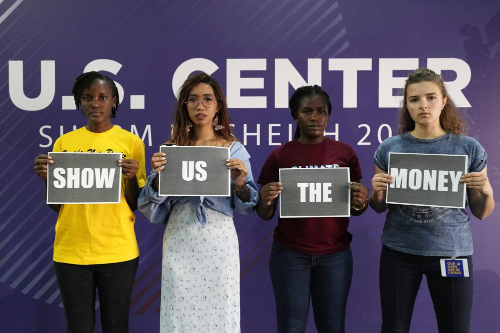 Vanessa Nakate, of Uganda, from left, Mitzi Jonelle Tan, of the Philippines, Precious Kalombwana, of Zambia, and Dominika Lasota, of Poland, hold signs that read “show us the money” at the U.S. Center at the COP27 U.N. Climate Summit, Friday, 11 November 2022, in Sharm el-Sheikh, Egypt. Photo: Peter Dejong / AP Photo