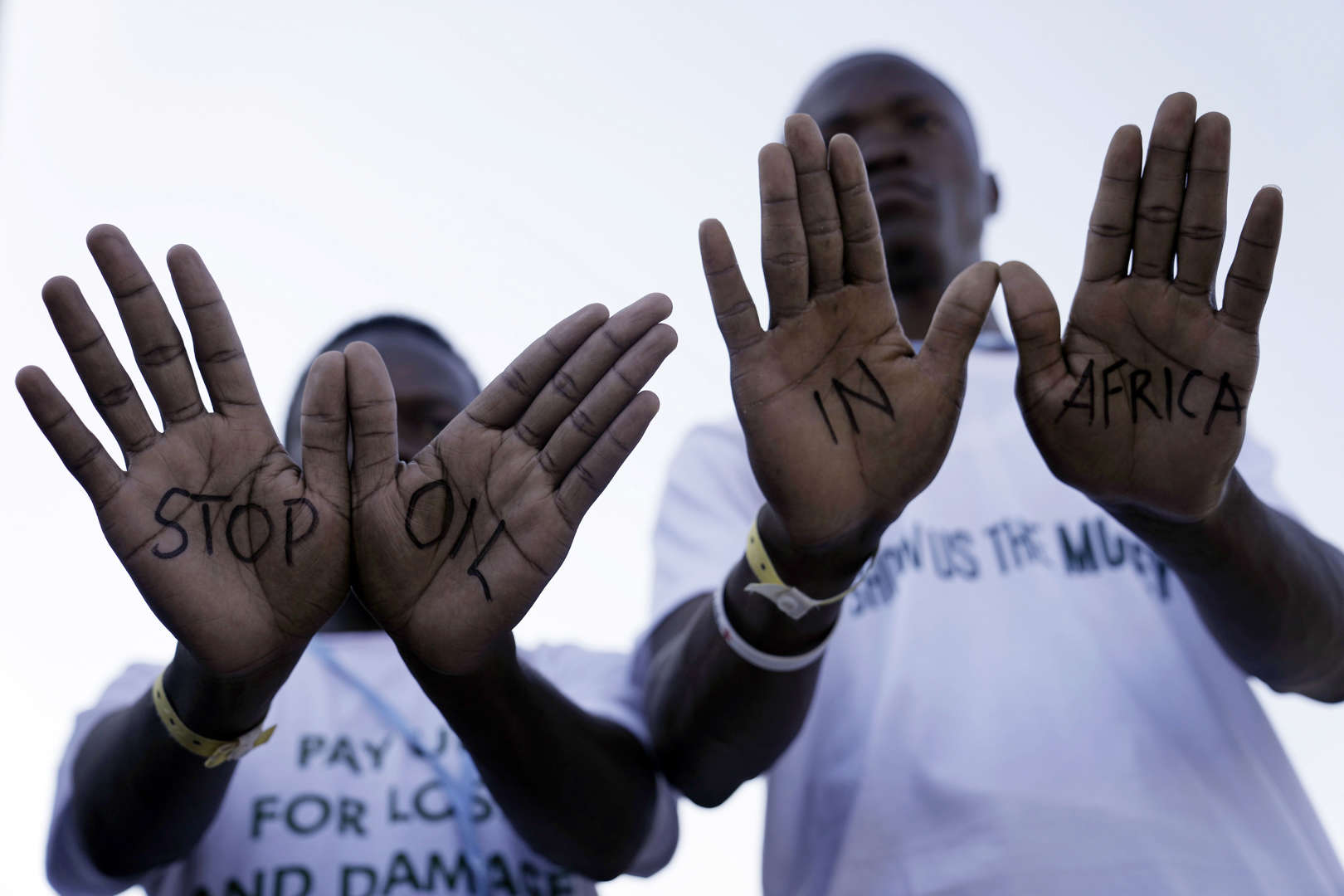 Demonstrators show “stop oil in Africa” written on their hands during a protest with Stop Pipelines coalition against pipelines in East Africa at the COP27 U.N. Climate Summit, Friday, 11 November 2022, in Sharm el-Sheikh, Egypt. Photo: Nariman El-Mofty / AP Photo