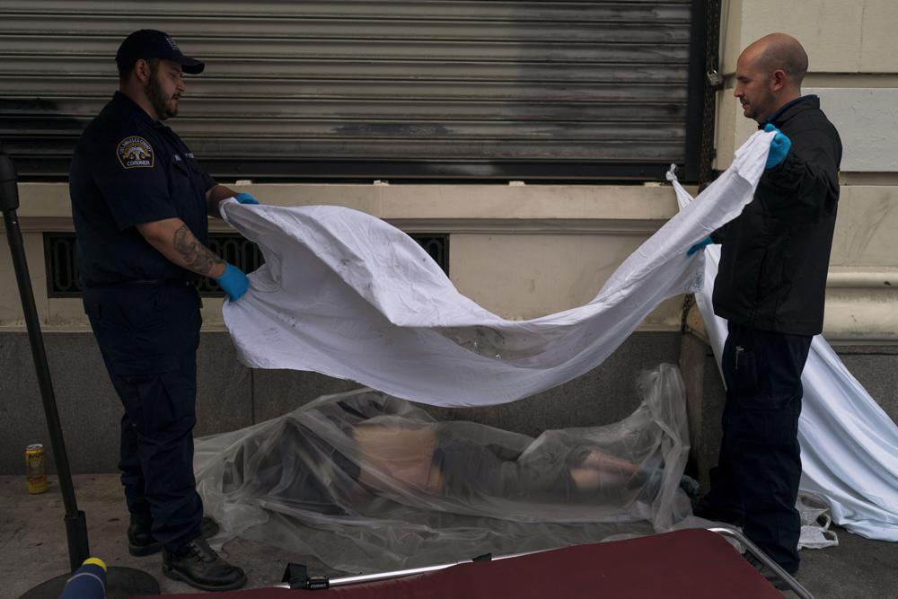 Forensic assistant Laurentiu Bigu, left, and investigator Ryan Parraz from the Los Angeles County coroner’s office cover the body of a homeless man found dead on a sidewalk in Los Angeles, Monday, 18 April 2022. The 60-year-old man died from the effects of methamphetamine, according to his autopsy report. Nearly 2,000 homeless people died in the city from April 2020 to March 2021, a 56 percent increase from the previous year, according to a report released by the Los Angeles County Department of Public Health. Overdose was the leading cause of death, killing more than 700. Photo: Jae C. Hong / AP Photo