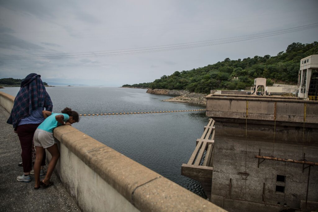 A visitor leans over the ridge of the Kariba dam in Kariba, Zimbabwe on 20 January 2020. Photo: Guillem Sartorio / AFP / Getty Images