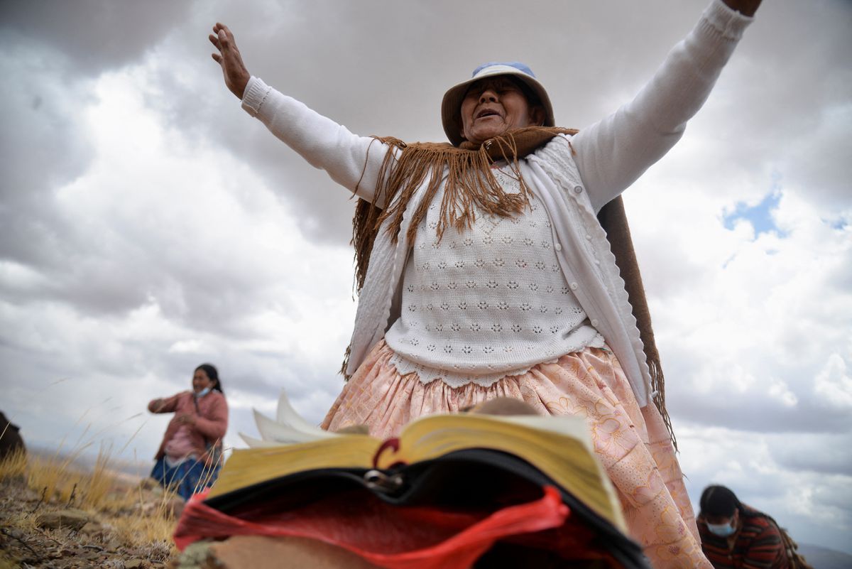 An indigenous woman raises her hands in prayer asking for rain in the Lloko Lloko community, in Tihuanacu, Bolivia, on 23 November 2022. Photo: Claudia Morales / REUTERS