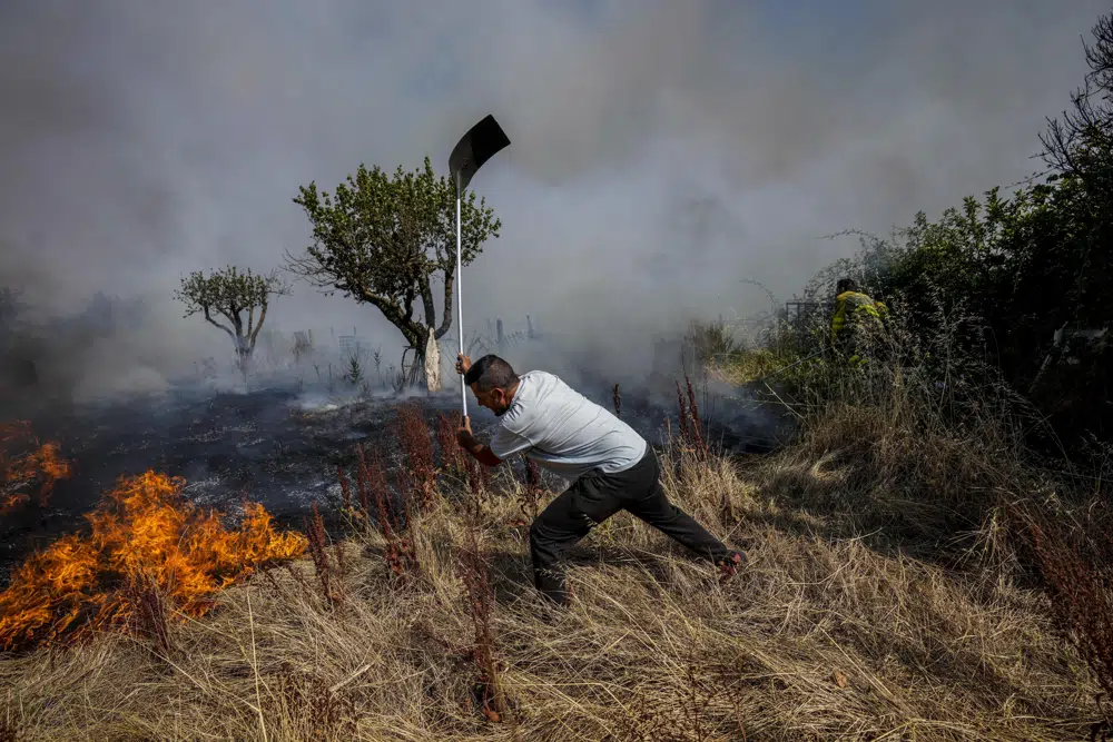 A local resident fights a forest fire with a shovel during a wildfire in Tabara, north-west Spain, Tuesday, 19 July 2022. Spain’s national weather service said preliminary data indicates that 2022 will finish with average daily temperatures above 15 degrees Celsius (59 degrees Fahrenheit) for the first time since records started in 1961. It says that the four hottest years on record for the southern European country have all come since 2015. Photo: Bernat Armangue / AP Photo