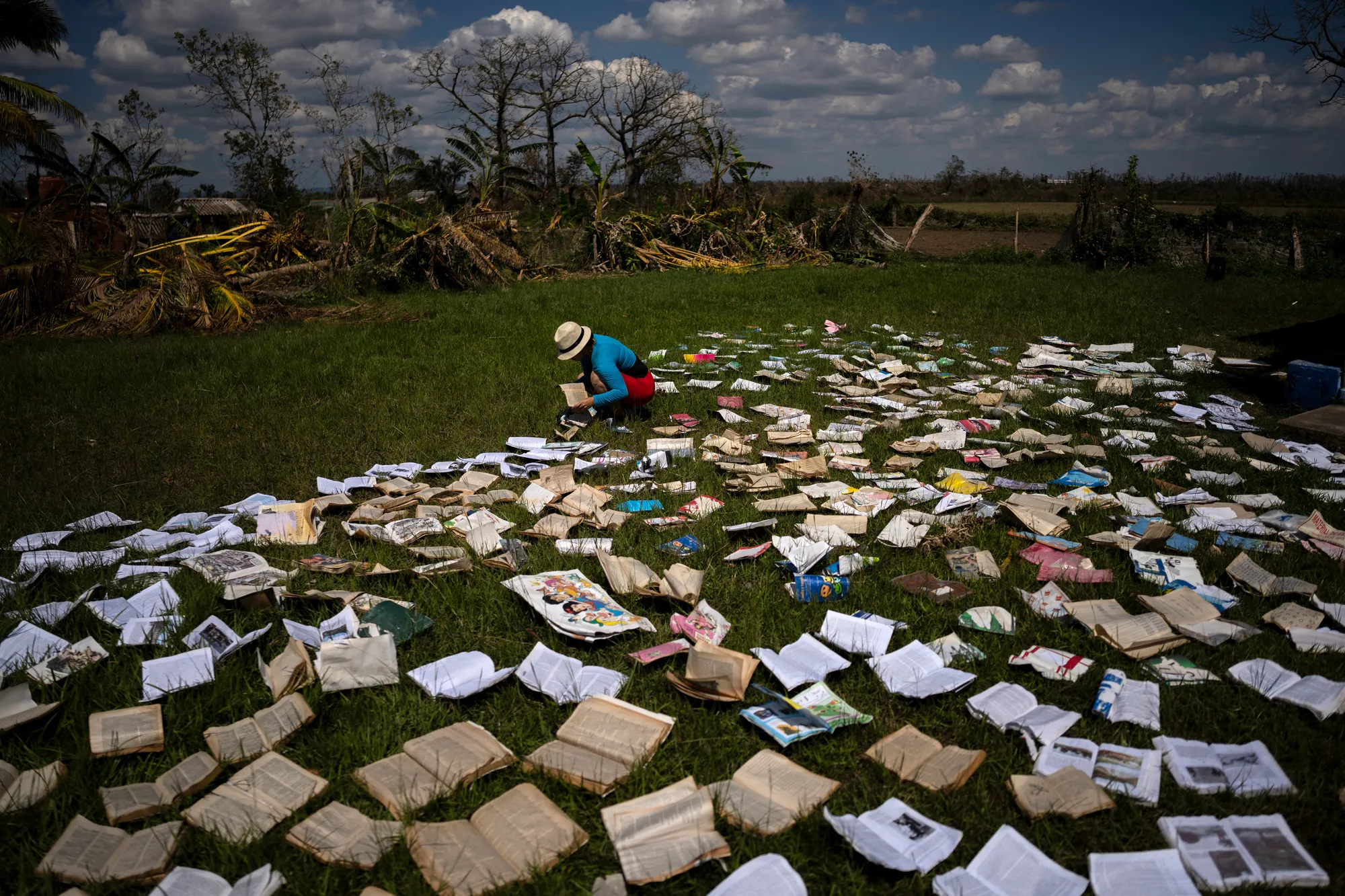 ​​A teacher dries out books at a school that was heavily damaged by Hurricane Ian in La Coloma, in the province of Pinar del Rio, Cuba, on 5 October 2022. Photo: Ramon Espinosa / AP Photo