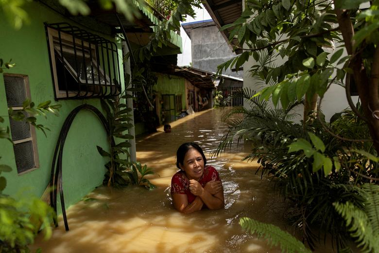 A woman wades through chest-deep flood after Super Typhoon Noru, in San Ildefonso, Bulacan province, Philippines, 26 September 2022. Photo: Eloisa Lopez / REUTERS