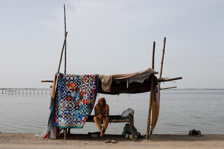 A flood victim takes refuge along a road in a makeshift tent, following rains and floods during the monsoon season in Mehar, Pakistan, 29 August 2022. Photo: Akhtar Soomro / REUTERS