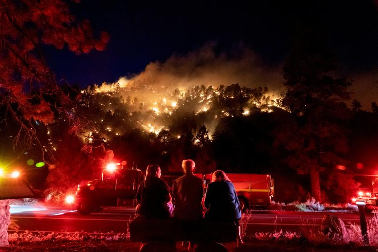 Residents watch part of the Sheep Fire wildfire burn through a forest on a hillside near their homes in Wrightwood, California, 11 June 2022. Photo: Kyle Grillot / REUTERS