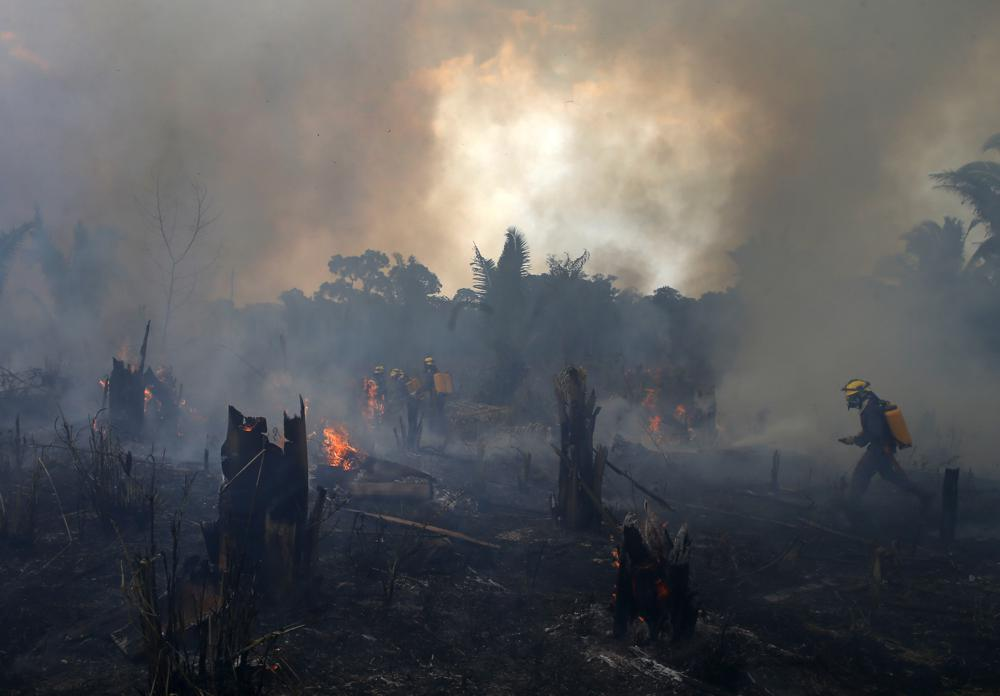 Fire brigade members work to put out fires in Apui, Amazonas state, Brazil, 21 September 2022. Deforestation in the Brazilian Amazon slowed slightly in 2022, a year after a 15-year high, according to closely watched numbers published Wednesday, 30 November 2022. Edmar Barros / AP Photo