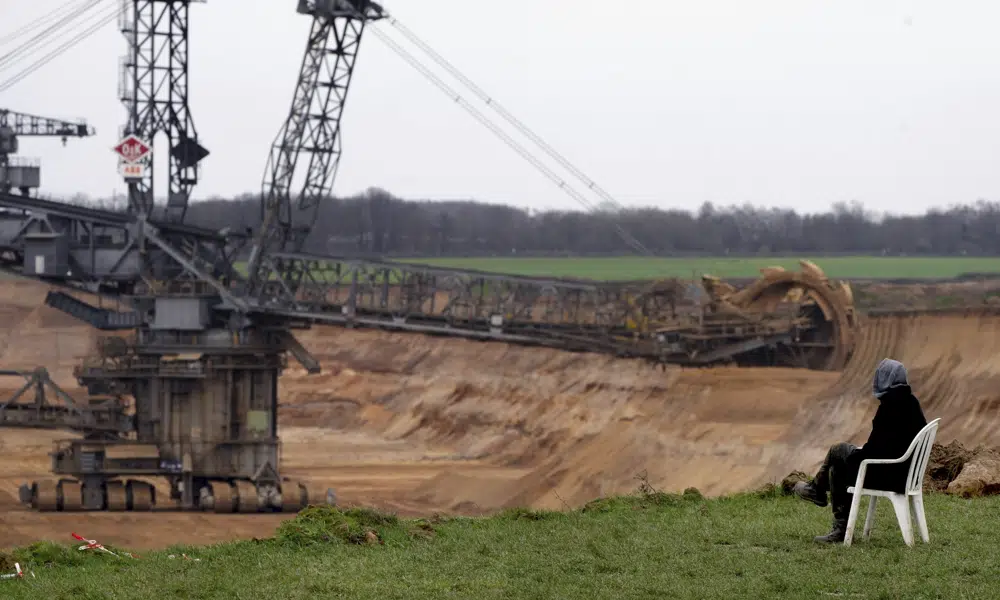A person sits in a chair next to the Garzweiler lignite opencast mine at the village Luetzerath near Erkelenz, Germany, Tuesday, 10 January 2023. A court in Germany rejected a last-ditch attempt by climate activists to stay in an abandoned village which was due to be cleared for the expansion of a coal mine that became a battleground between the government and environmentalists. Photo: Michael Probst / AP Photo