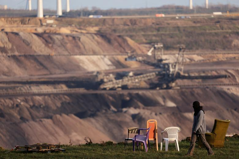 An environmental activist walks at the edge of the open-cast lignite mine of Germany's utility RWE as police officers prepare for the planned evacuation of Luetzerath, 3 January 2023. Photo: Thilo Schmuelgen / REUTERS