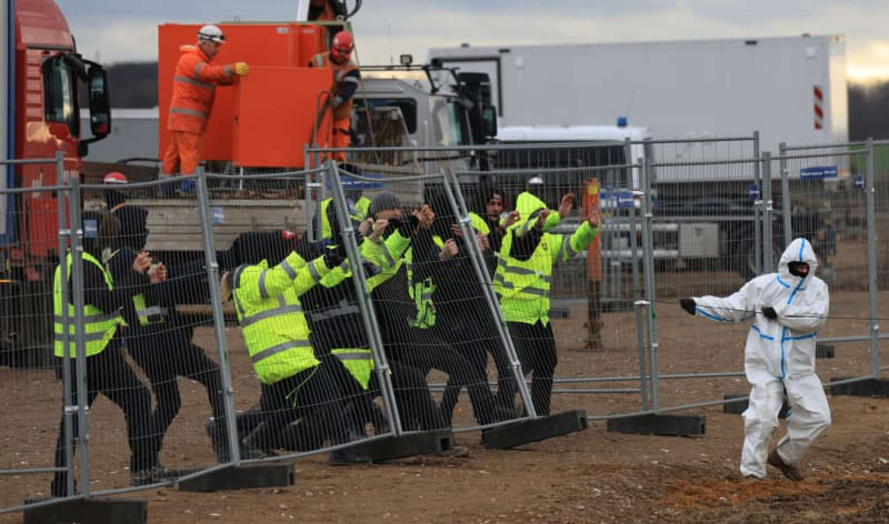 Climate protection activists try to knock down a fence on the outskirts of Luetzerath. The village of Luetzerath is to be mined for the expansion of the Garzweiler II open pit lignite mine. Photo: Oliver Berg / DPA