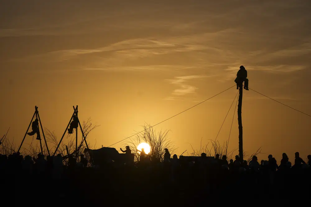 Climate activists sit in so-called tripods and on a tree trunk at the village of Luetzerath near Erkelenz, Germany, Tuesday, 10 January 2023. The village of Luetzerath had to be demolished to expand the Garzweiler lignite coal mine near the Dutch border. Photo: Michael Probst / AP Photo
