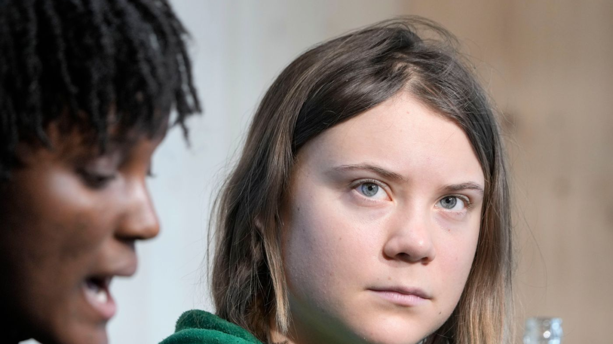 Climate activist Greta Thunberg of Sweden listens as Vanessa Nakate of Uganda speaks at a press conference at the World Economic Forum in Davos, Switzerland on 19 January 2023. The activists urged attendees to give less power in the climate-change fight to oil companies. Photo: AP
