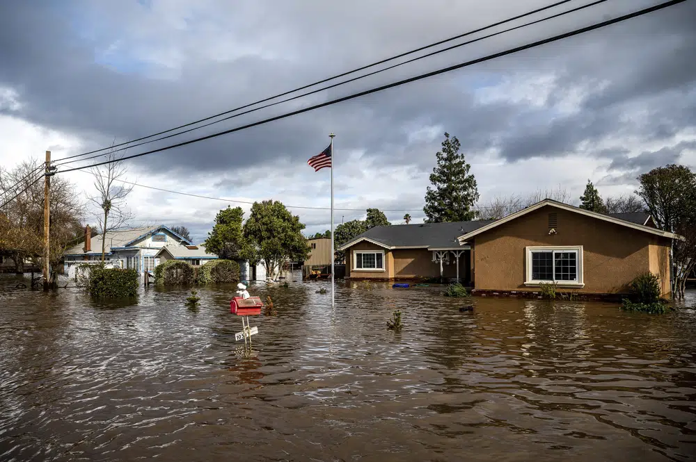 Floodwaters surround homes on Thornton Road in Merced, California, as storms battered the state on Tuesday, 10 January 2023. In California, only about 230,000 homes and other buildings have flood insurance policies, which are separate from homeowners insurance. Photo: Noah Berger / AP Photo